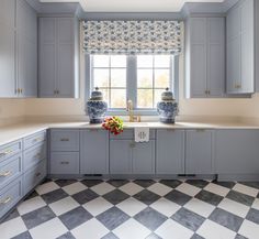 a kitchen with checkered flooring and blue cabinetry is pictured in this image