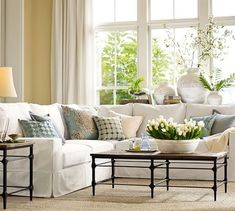 a living room filled with white furniture and lots of window sill space in front of it