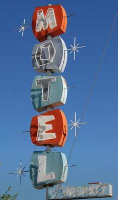 an old neon motel sign with the letters m and e on it's side