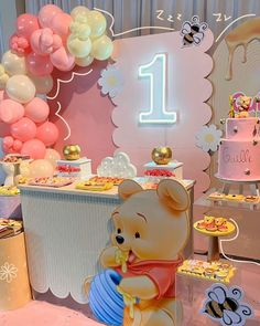 a winnie the pooh themed birthday party with balloons and desserts for one year old