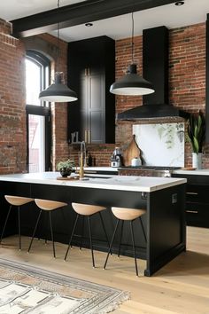 a kitchen with black cabinets and an island in the middle, surrounded by stools