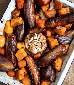 a tray filled with carrots, potatoes and other food on top of a table