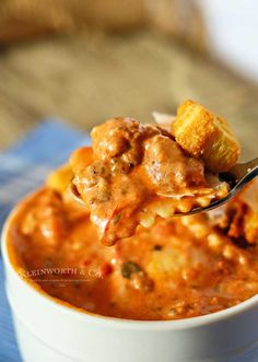 a spoon full of soup with meatballs and bread