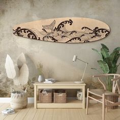 a wooden surfboard hanging on the wall above a table with baskets and vases