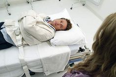 a woman laying in a hospital bed with her head on the pillow