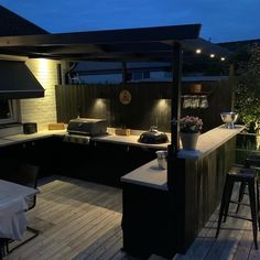 an outdoor kitchen is lit up at night