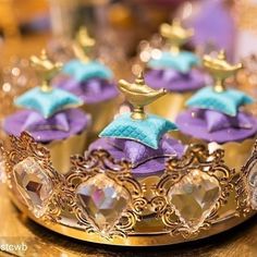 a tiara with purple and blue decorations on it sitting on top of a table