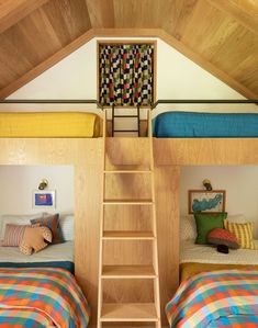 two bunk beds with ladders to the top and bottom, in a loft bedroom