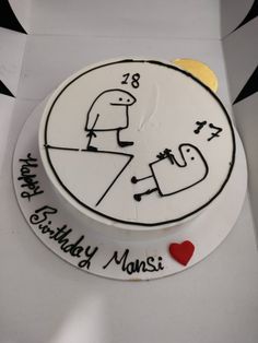 a white cake with black writing on it and a red heart in the middle that says happy birthday monsset