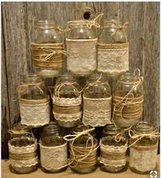 there are many mason jars with lace on them