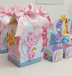 there are several boxes with different designs on them and one has a pink ribbon around the top