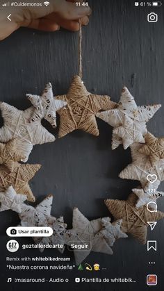 a hand holding an ornament made out of paper stars on a black background