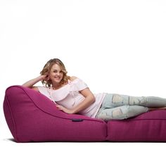 a woman sitting on a pink bean bag chair