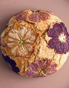 an orange and grapefruit cake on a plate with purple flowers around the edges