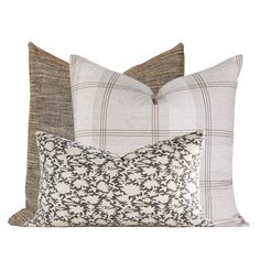 three pillows with different patterns on them, one in grey and the other in white