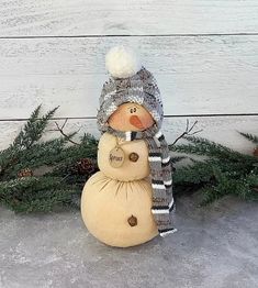 a small snowman with a knitted hat and scarf on it's head