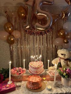 a table topped with lots of cakes and balloons