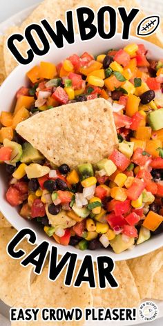 a white bowl filled with black beans, corn and avocado salsa next to tortilla chips