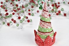 an ornament shaped like a christmas tree with red and green ribbons on it