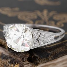 an antique diamond ring sits on top of a book