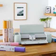 a table topped with different types of crafting supplies next to a printer and crayons