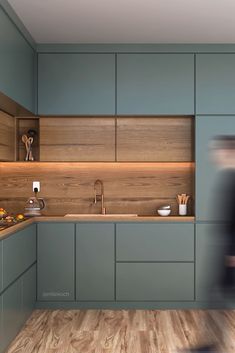 a blurry photo of a kitchen with blue cabinets and wood flooring on the walls