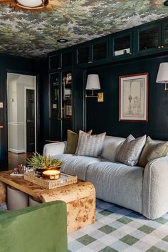 a living room filled with furniture and green walls