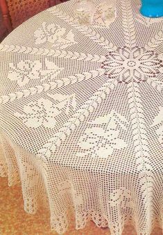 a white doily on a table with a blue vase