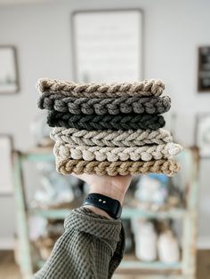 a person holding up several different colored crocheted items