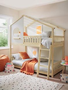 a child's bedroom with bunk beds and orange pillows on the floor, in front of a window