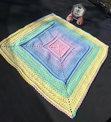 a crocheted blanket sitting on top of a black table next to a car