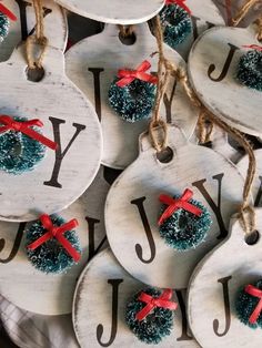 christmas ornaments are hanging from twine with red bows on them and the word joy is spelled in black letters