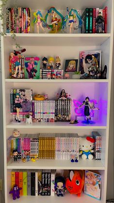 a white book shelf filled with lots of books and figurines on top of it