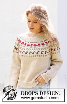 a woman wearing a sweater with flowers on it and the words drops design above her