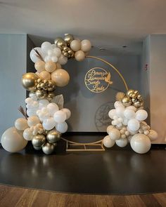 a balloon arch with gold and white balloons