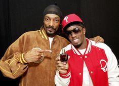 two men standing next to each other holding wine glasses