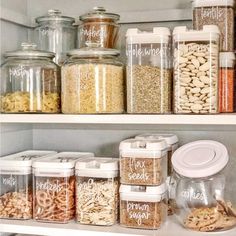 an organized pantry filled with cereal, nuts and other things to eat in glass containers