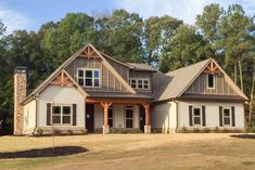 a large house with lots of windows in the front yard and trees in the back