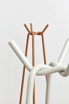 an abstract sculpture made out of wood and white plastic, with two wooden sticks sticking out of it