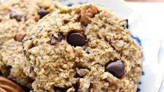 two cookies with chocolate chips and pecans on a blue and white plate