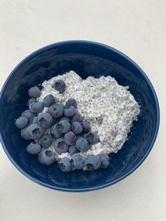 a bowl filled with oatmeal and blueberries on top of a table