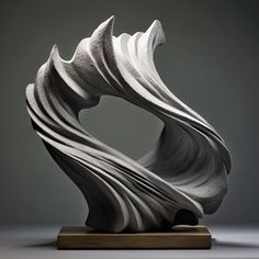 an abstract sculpture is displayed on a wooden base in front of a gray background with light coming through it