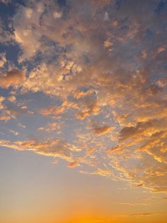 the sun is setting behind some clouds in the sky