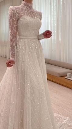 a woman in a white wedding dress is posing for the camera with her hands on her hips