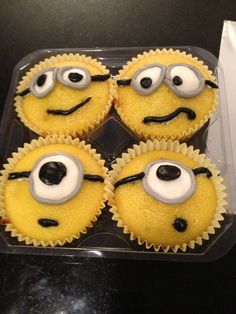 four yellow cupcakes with googly eyes in a plastic container