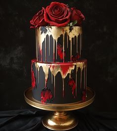 a three tiered cake decorated with red and black icing, topped with a rose