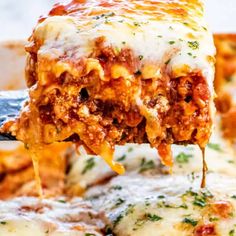 a slice of lasagna being lifted from a casserole dish with cheese