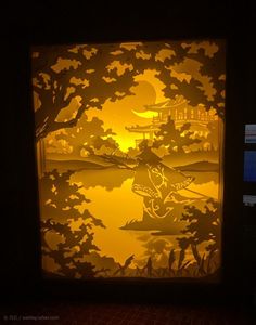 the paper cut art is displayed in front of a window