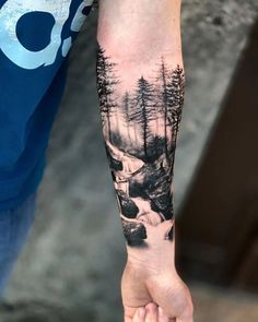 a man with a forest tattoo on his arm