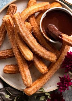 french fries on a plate with dipping sauce in the middle and flowers around them, ready to be eaten